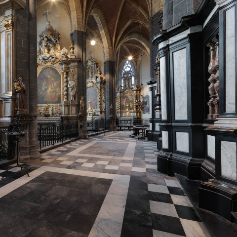 Prächtiges Kathedraleninterieur mit hohen Gewölbedecken, kunstvollen Gemälden und detaillierten Stuckarbeiten. Der Marmorboden und das sanfte Licht schaffen eine ruhige Atmosphäre.